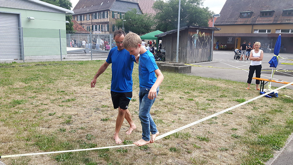 Balancieren über eine Slackline bei der Jugendabteilung Berg und Sport Balancieren über eine Slackline bei der Jugendabteilung Berg und Sport